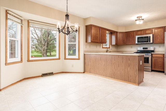 kitchen featuring light countertops, visible vents, stainless steel appliances, and a healthy amount of sunlight