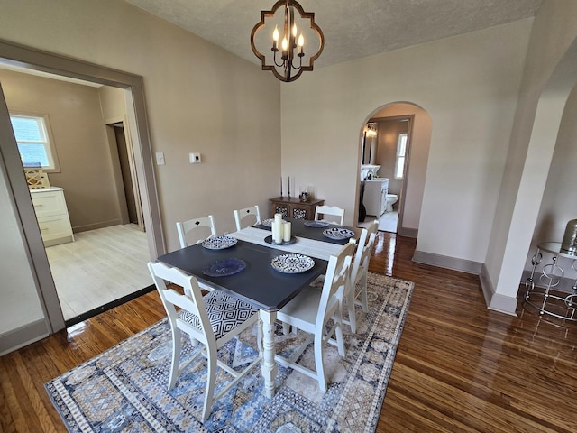 601 Powell St, Streator, IL 61364 - dining space featuring arched walkways, wood finished floors, a notable chandelier, and baseboards