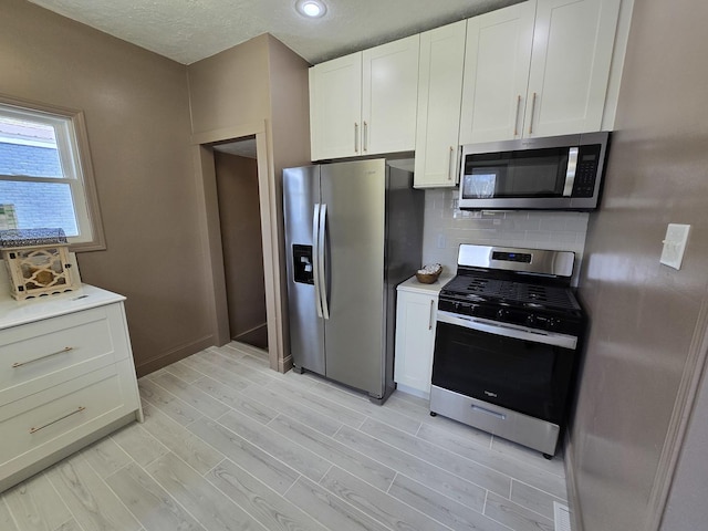 601 Powell St, Streator, IL 61364 - kitchen with white cabinets, light wood-style floors, light countertops, and appliances with stainless steel finishes
