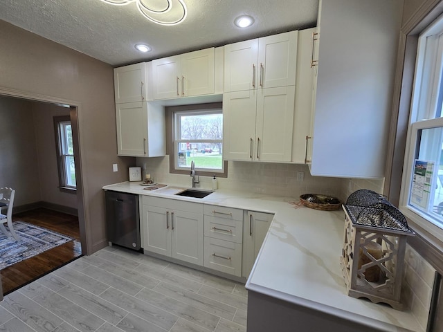 601 Powell St, Streator, IL 61364 - kitchen featuring tasteful backsplash, dishwasher, a sink, white cabinetry, and light wood-style flooring