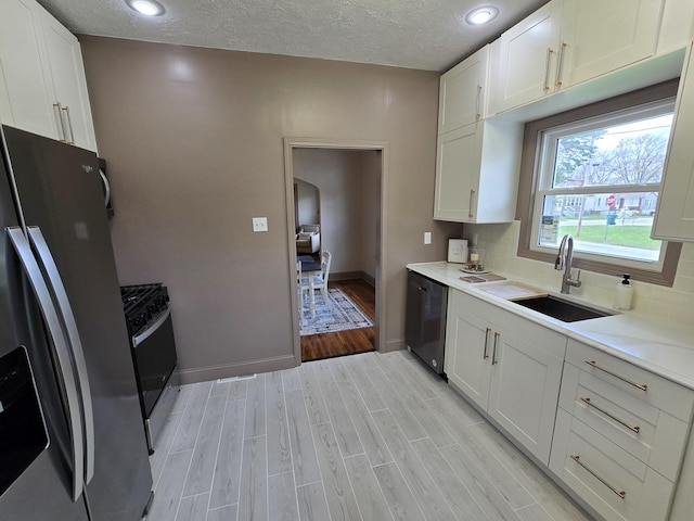 601 Powell St, Streator, IL 61364 - kitchen with stainless steel appliances, light wood finished floors, baseboards, and a sink