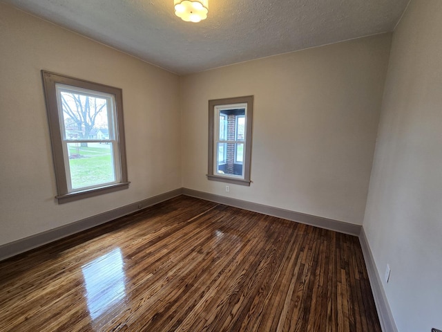 601 Powell St, Streator, IL 61364 - empty room featuring dark wood-style flooring, baseboards, and plenty of natural light