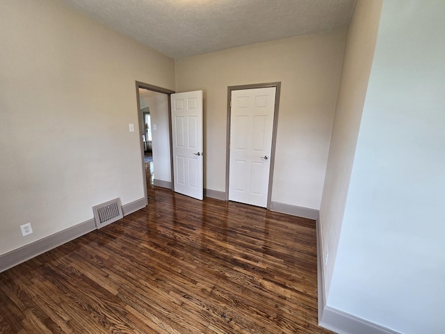 601 Powell St, Streator, IL 61364 - unfurnished bedroom featuring a textured ceiling, wood finished floors, baseboards, and visible vents