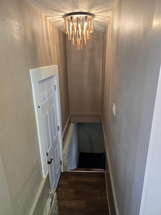 601 Powell St, Streator, IL 61364 - stairs with a chandelier, a textured wall, and wood finished floors