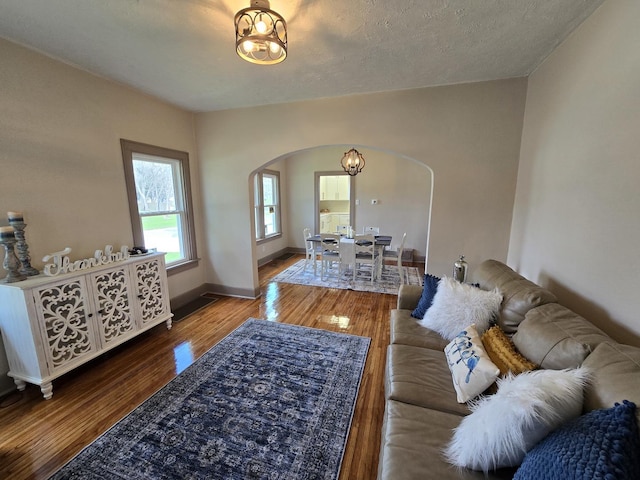 601 Powell St, Streator, IL 61364 - living room featuring a chandelier, arched walkways, wood finished floors, and baseboards
