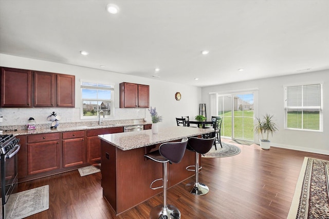 2834 Ketchum Ct, Yorkville, IL 60560 - kitchen featuring stainless steel dishwasher, a center island, dark wood-style flooring, a sink, and range with gas stovetop