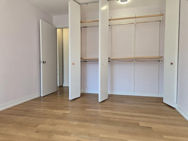 1115 S Plymouth Ct Unit 303, Chicago, IL 60605 - unfurnished bedroom featuring light wood finished floors, baseboards, and two closets