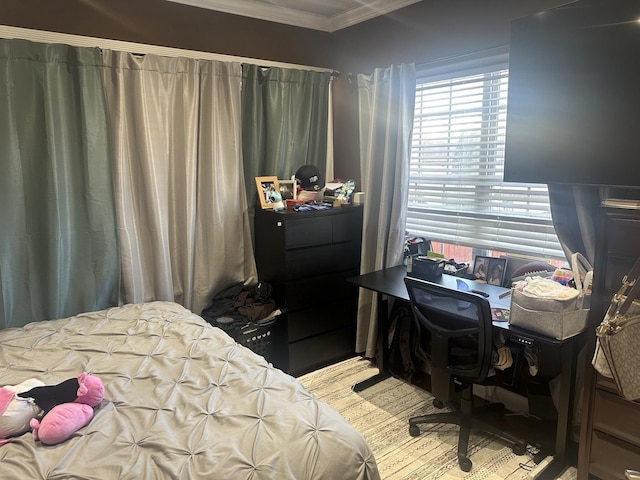 bedroom with ornamental molding and wood finished floors