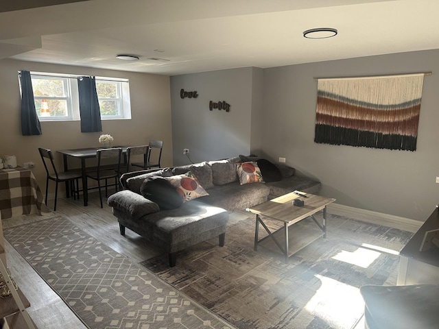 living area featuring baseboards and wood finished floors