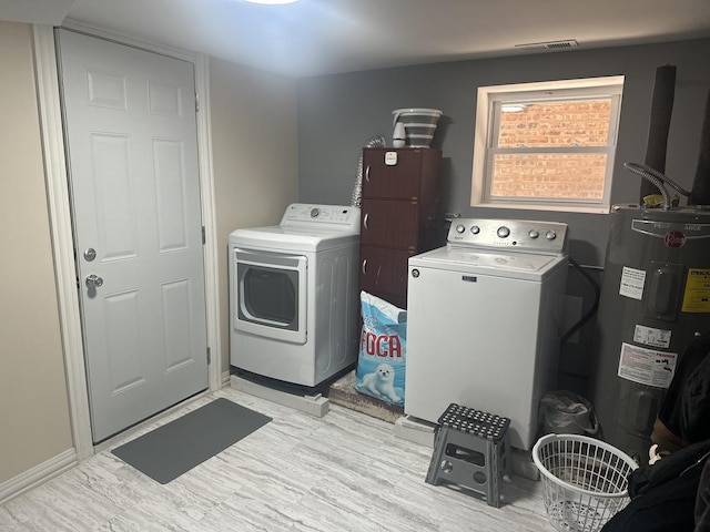 laundry room with laundry area, light wood-style flooring, visible vents, washing machine and clothes dryer, and electric water heater