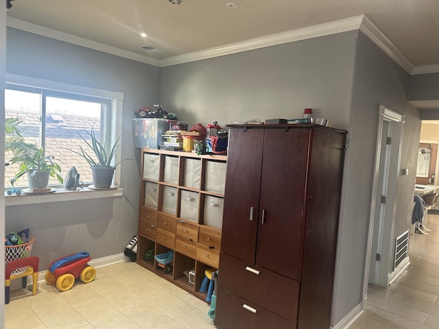 interior space featuring tile patterned flooring, visible vents, baseboards, and crown molding
