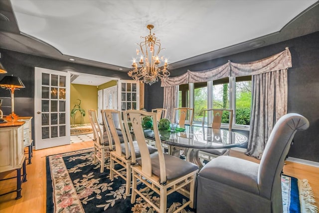dining room featuring recessed lighting, wood finished floors, a notable chandelier, and french doors
