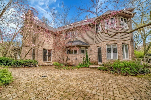 rear view of house with a patio area and brick siding