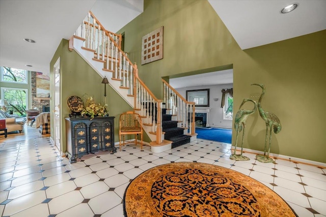 entrance foyer with plenty of natural light, stairs, and a fireplace