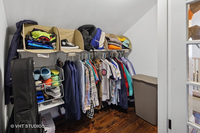 walk in closet with wood finished floors and lofted ceiling