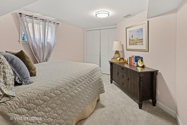 bedroom with baseboards, visible vents, a closet, and light colored carpet