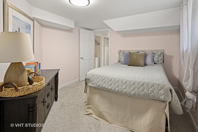 bedroom with baseboards and light colored carpet