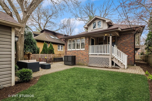 rear view of property with a fenced backyard, an outdoor hangout area, brick siding, and a yard