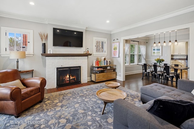 living room with baseboards, recessed lighting, a brick fireplace, wood finished floors, and ornamental molding