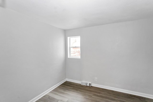 unfurnished room with visible vents, baseboards, and wood finished floors