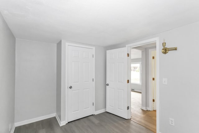 unfurnished bedroom with wood finished floors and baseboards
