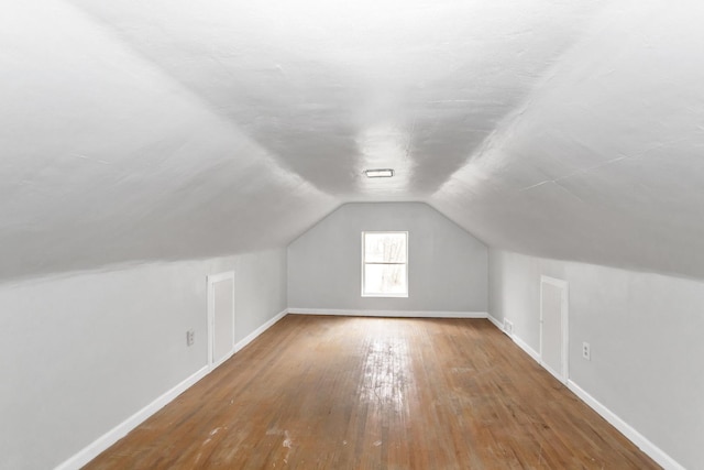 bonus room featuring visible vents, hardwood / wood-style flooring, baseboards, and lofted ceiling