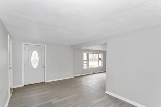 foyer entrance with baseboards and wood finished floors