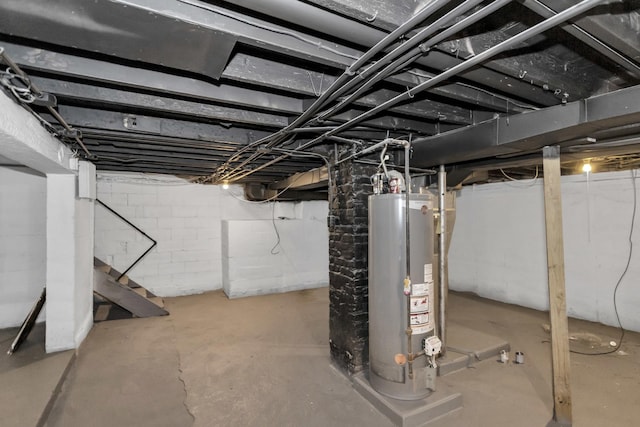 unfinished below grade area featuring stairs and water heater