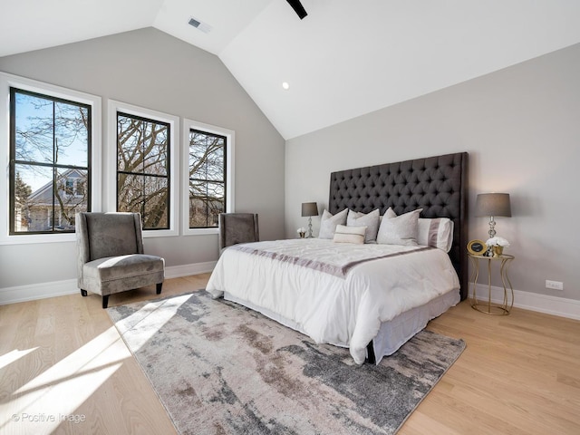 bedroom with visible vents, baseboards, a ceiling fan, wood finished floors, and lofted ceiling