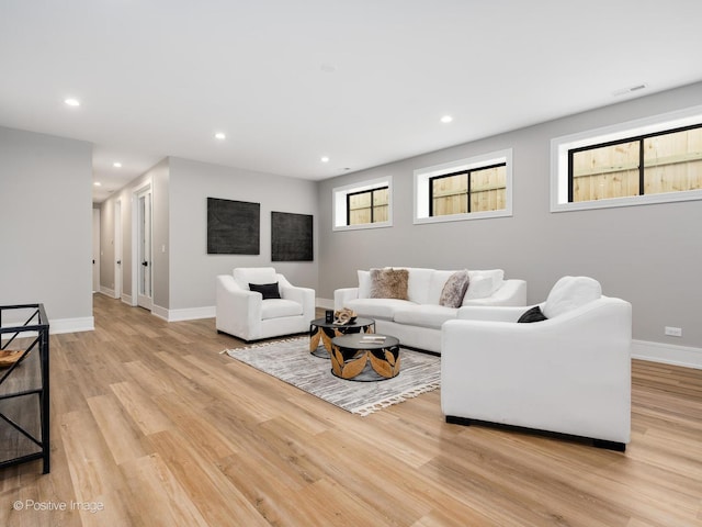 living area with light wood-type flooring, baseboards, visible vents, and recessed lighting
