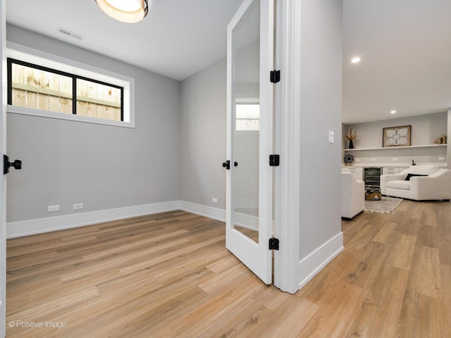 hallway featuring recessed lighting, light wood-style floors, baseboards, and visible vents