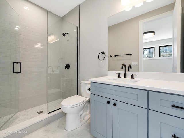 full bathroom with toilet, marble finish floor, a stall shower, and vanity