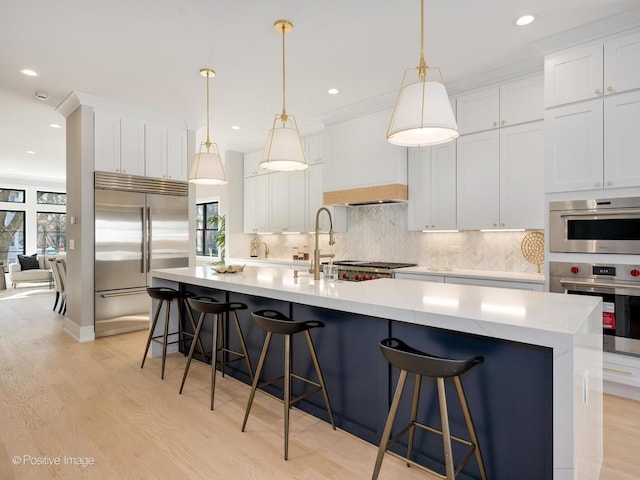 kitchen with light wood-style flooring, tasteful backsplash, stainless steel built in refrigerator, and recessed lighting