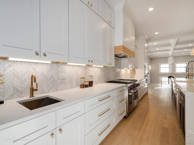 kitchen featuring premium range hood, recessed lighting, a sink, and stainless steel appliances