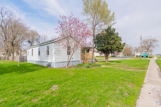 view of home's exterior with a yard and fence