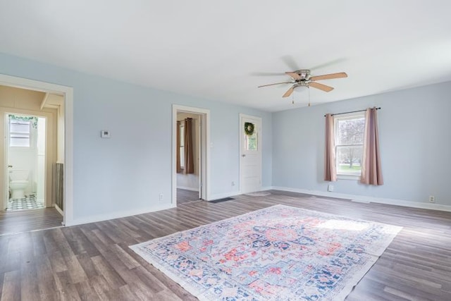 interior space with wood finished floors, baseboards, and multiple windows