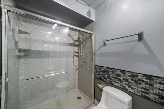 full bathroom featuring a stall shower and toilet