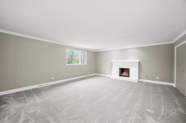 unfurnished living room featuring a brick fireplace, baseboards, crown molding, and carpet floors