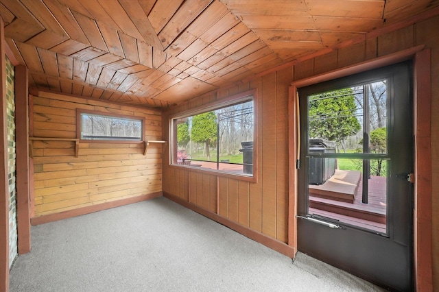 interior space featuring wooden ceiling, wooden walls, and baseboards
