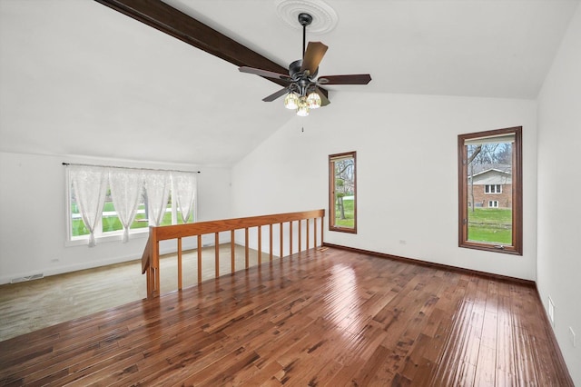 additional living space with visible vents, plenty of natural light, and lofted ceiling with beams