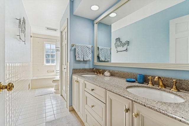 bathroom with a sink, visible vents, double vanity, and tile patterned flooring