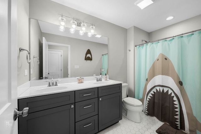 full bathroom with a sink, tile patterned floors, double vanity, and toilet