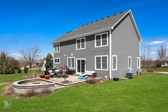 rear view of house with roof with shingles, a yard, a patio area, and central AC