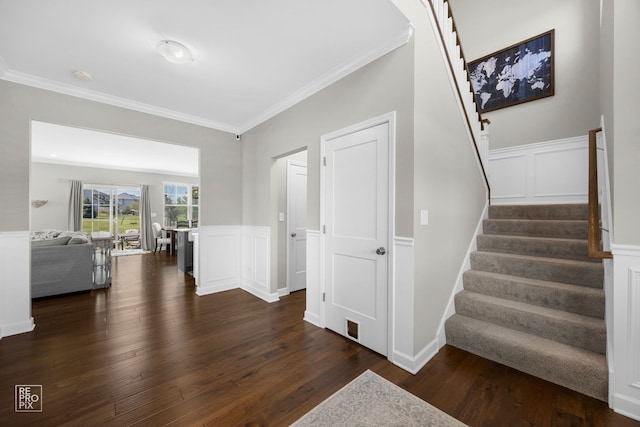 stairs featuring a decorative wall, wainscoting, ornamental molding, and wood finished floors