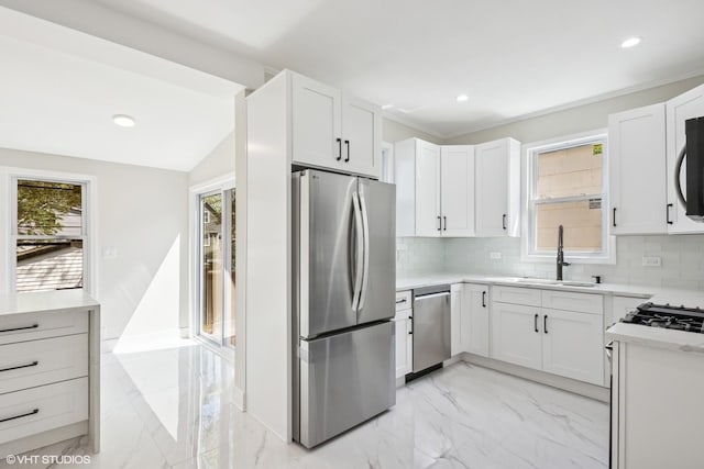 kitchen featuring marble finish floor, appliances with stainless steel finishes, and a wealth of natural light