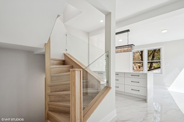 interior space with lofted ceiling, marble finish floor, and a chandelier