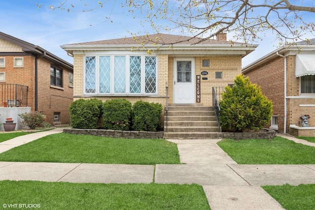 12947 S Exchange Ave, Chicago, IL 60633 - bungalow-style house with a shingled roof, a front lawn, and brick siding