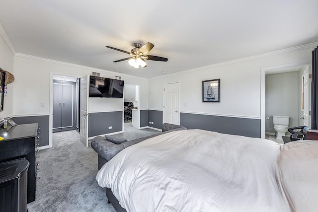bedroom with a ceiling fan, carpet, baseboards, ensuite bath, and ornamental molding