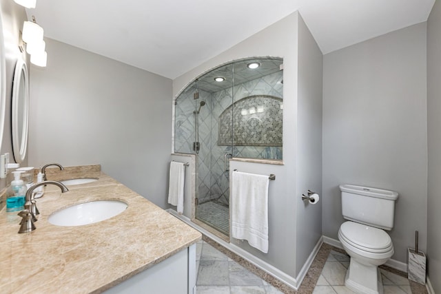 full bathroom with double vanity, toilet, baseboards, and a sink