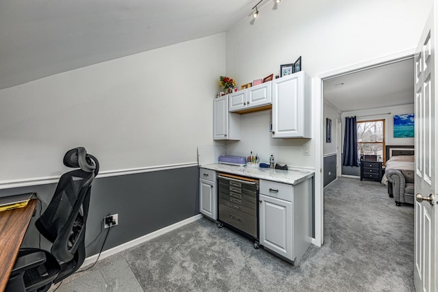 kitchen featuring beverage cooler, gray cabinets, light carpet, light stone countertops, and baseboards
